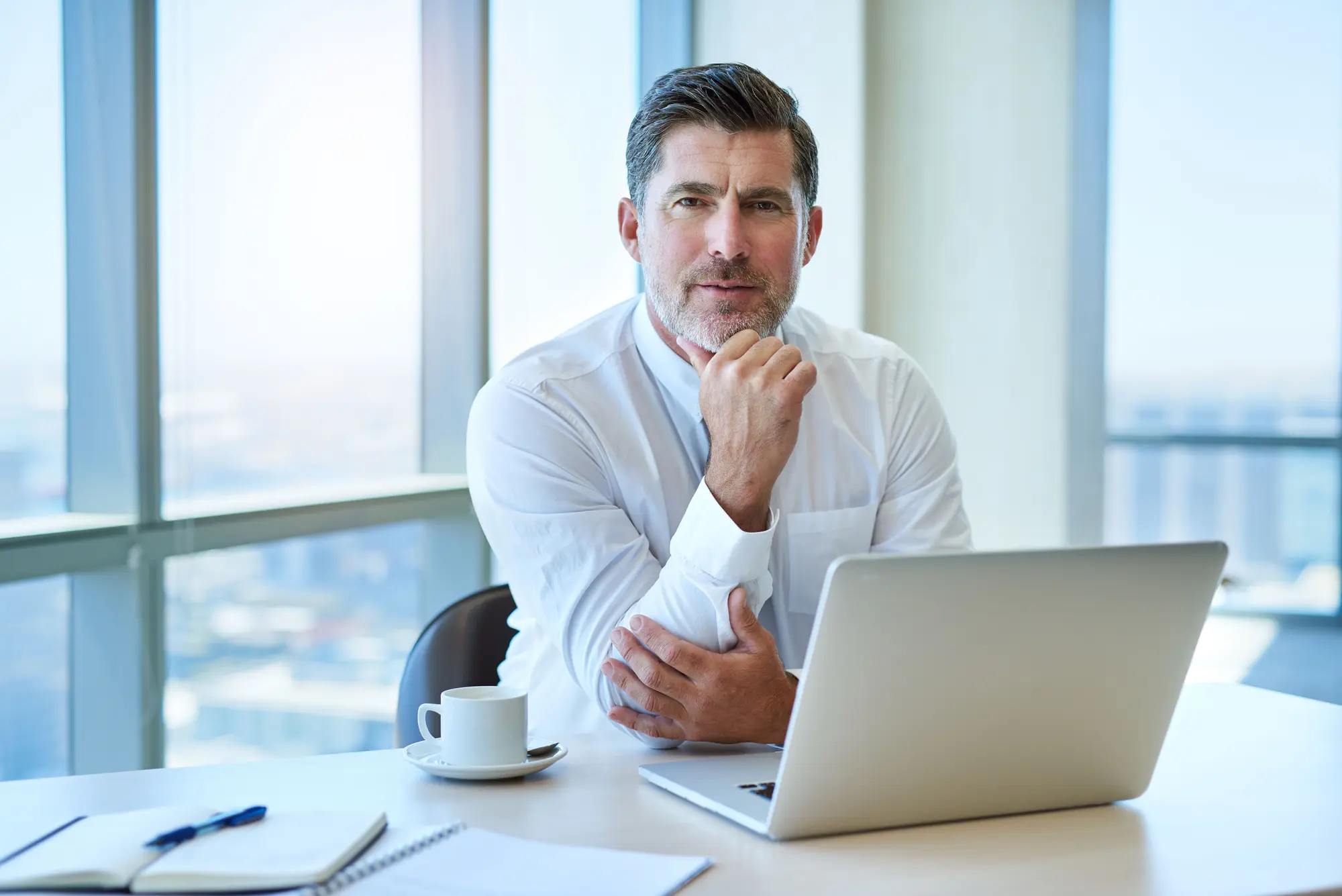 Portrait of a mature CEO using a laptop in his office representing small business accounting services in New Zealand