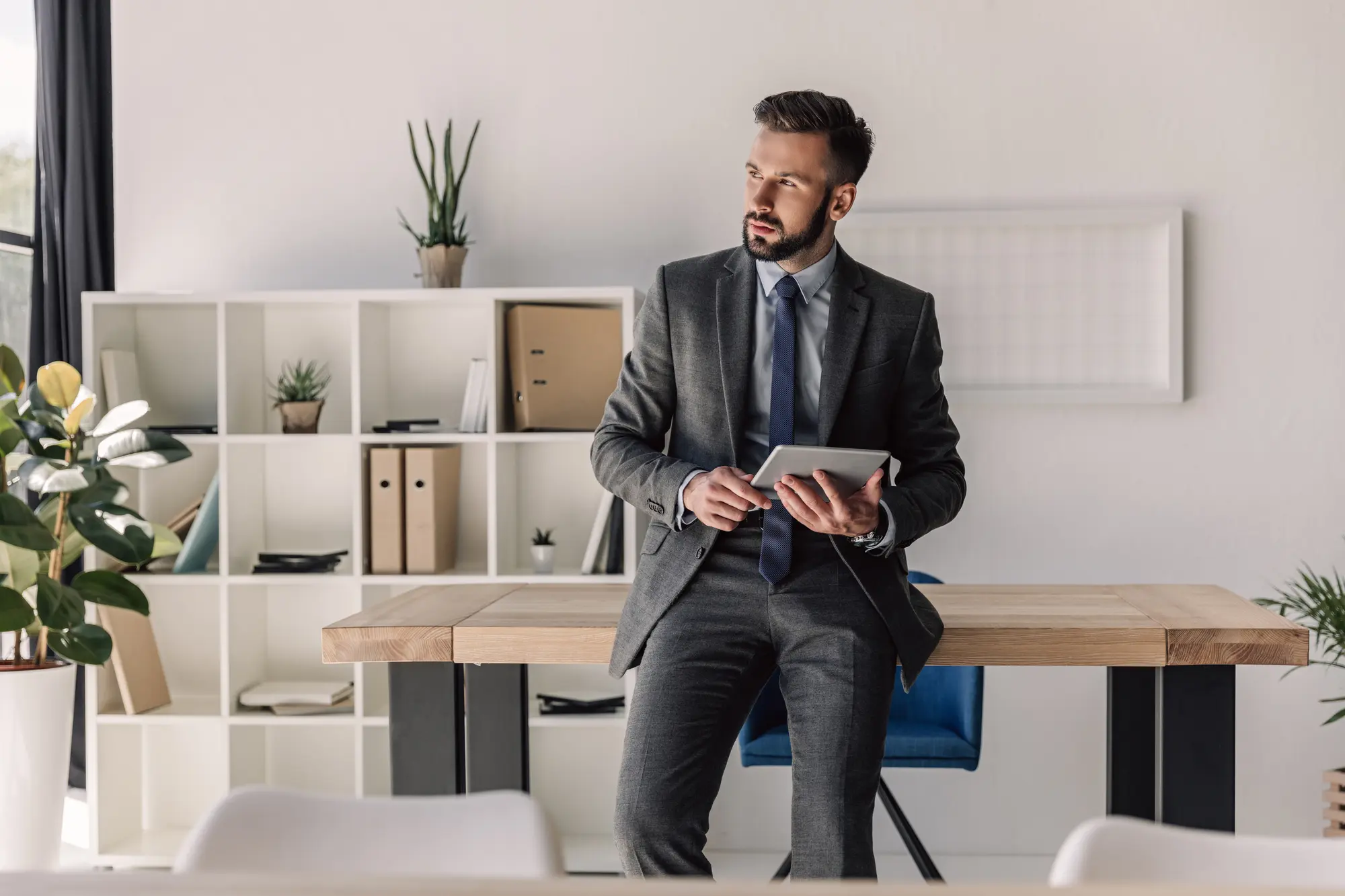 Business accountant in Wellington sitting at a desk with a tablet in a modern accounting firm office